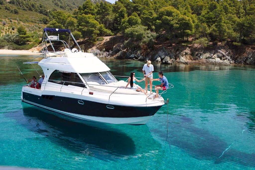 Small yacht anchored in a calm bay with people enjoying a peaceful boat trip in Sithonia, Halkidiki