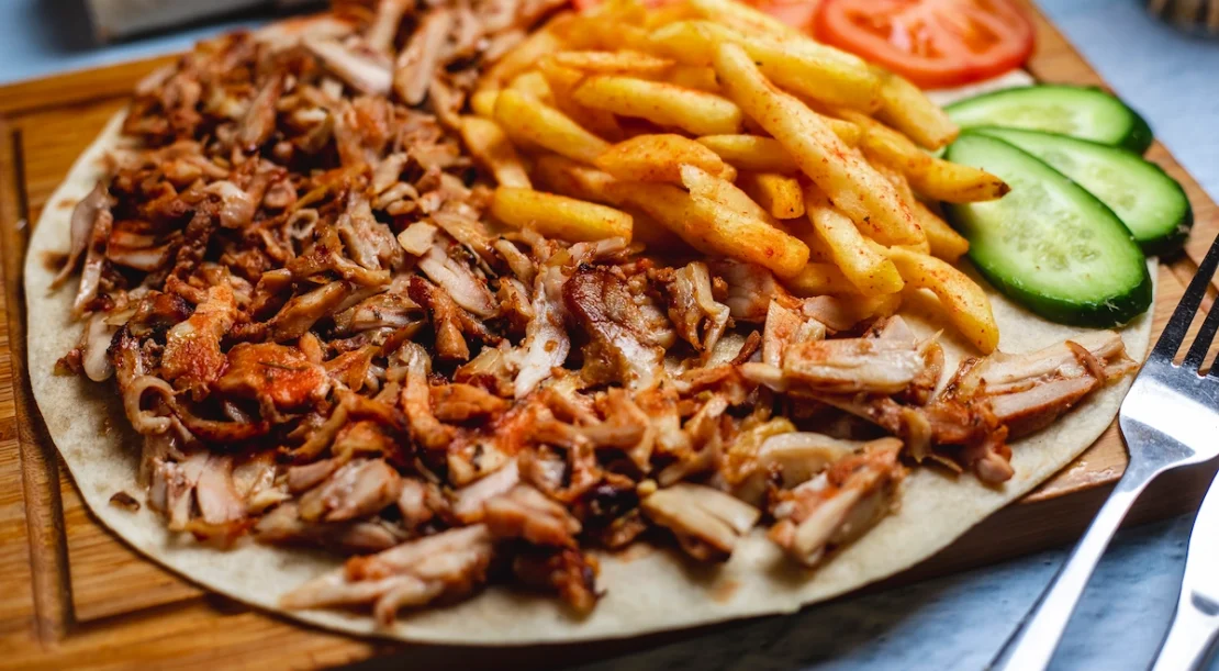 Delicious gyros plate with fries, fresh tomato and cucumber