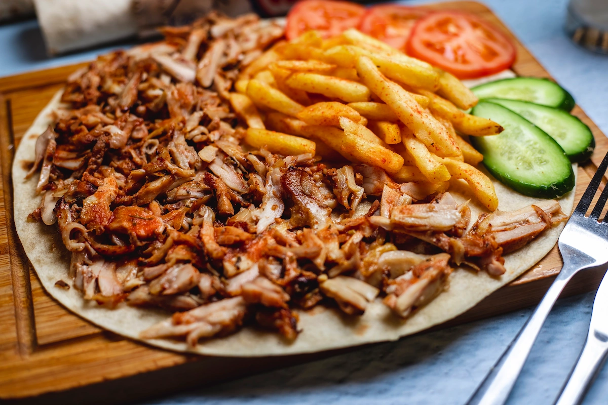 Delicious gyros plate with fries, fresh tomato and cucumber
